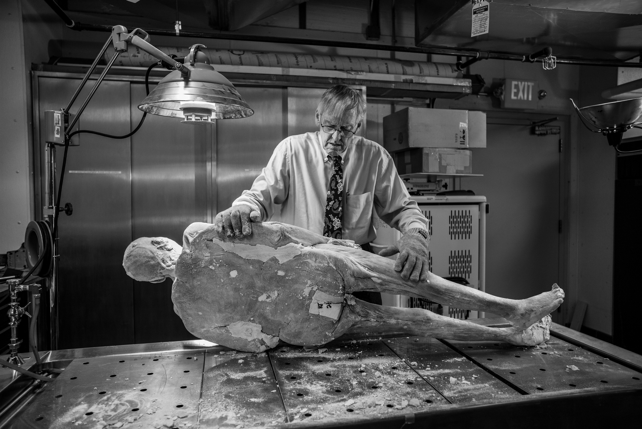 Picture of a man holding a frozen cadaver on its side